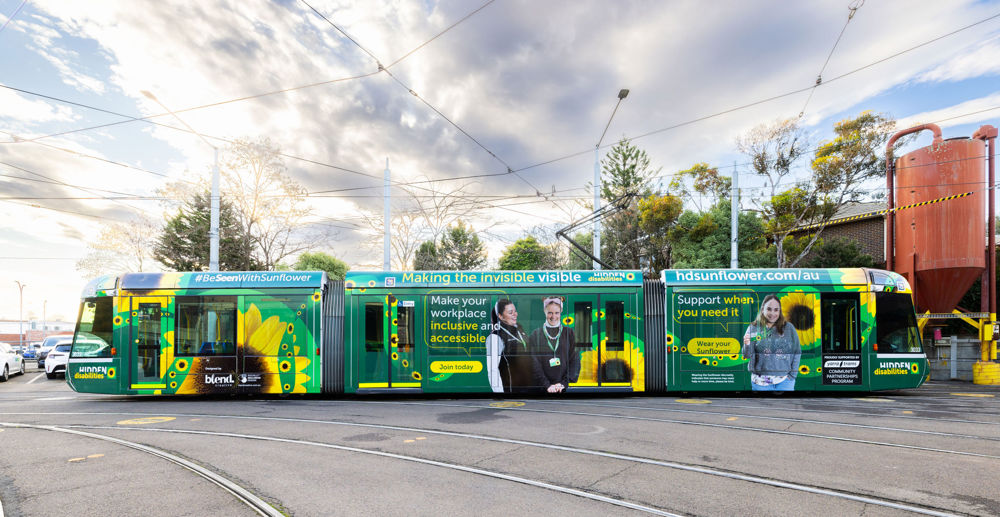 A C1 tram's livery is shown with yellow sunflowers on a green background